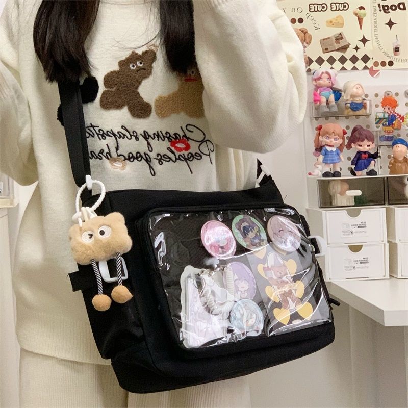 Black ita messenger bag with badges in the clear window