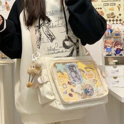 Cream ita messenger bag with pins in the large clear window