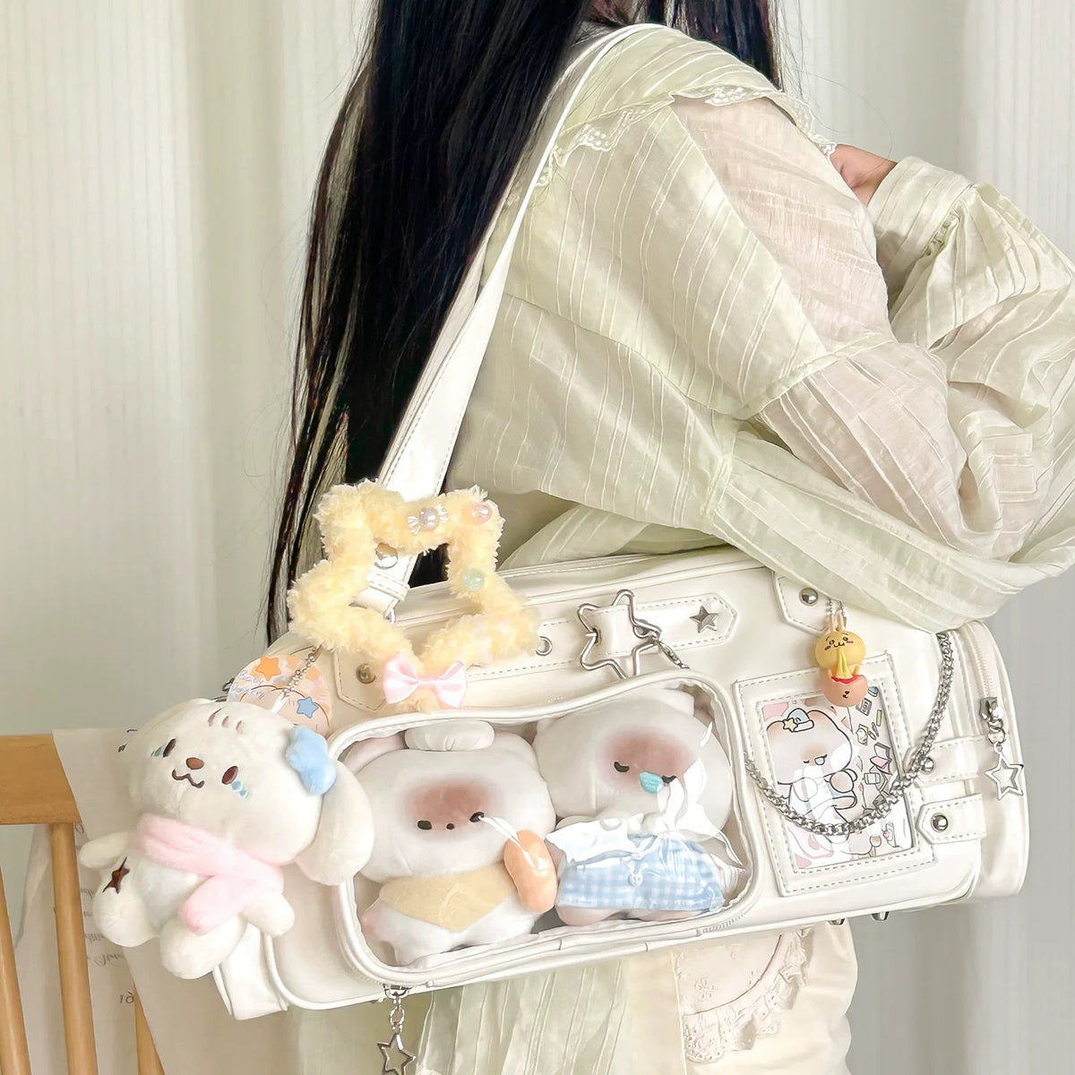 White ita Boston bag with plushies in the clear pockets